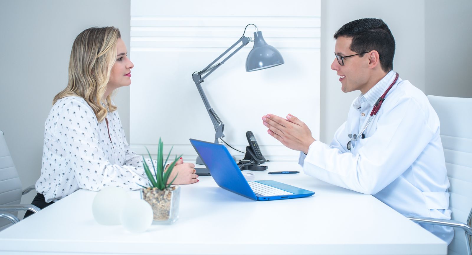 Médico conversando com paciente em consultório claro e moderno